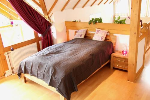 Schlafzimmer mit einem Bett mit einem Kopfteil aus Holz in der Unterkunft Haus Winkelchen in Cochem