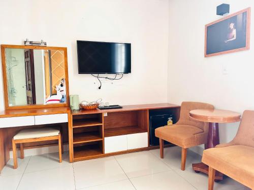 a room with a desk with a television and a chair at khách sạn Thiên Cung in Ho Chi Minh City