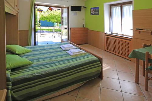 1 dormitorio con 1 cama en una habitación con paredes verdes en North Wind Camping & Apartment, en Domaso
