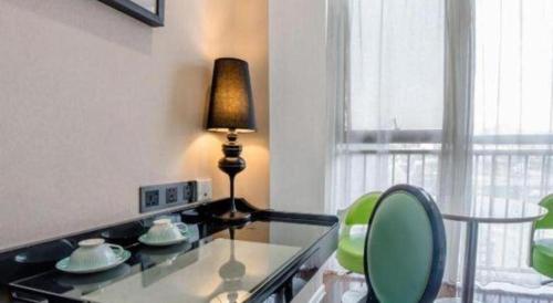 a lamp on a glass counter with a table and chairs at Xana Lite Anqing Yuexi Swan Squre Branch in Yuexi