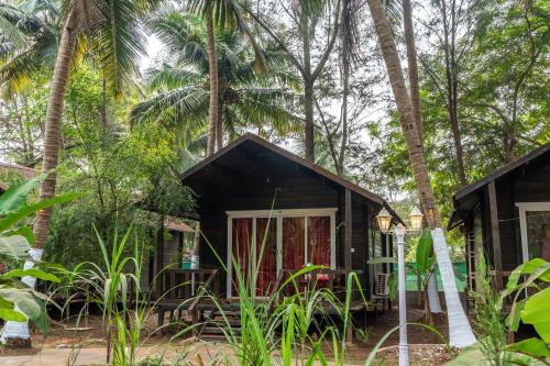 a cabin in the woods with palm trees at The Exotica Agonda in Agonda