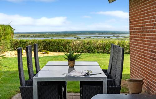 a table and chairs on a patio with a view at 3 Bedroom Cozy Home In Tarm in Tarm