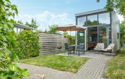 a patio with a table and chairs and an umbrella at One-Bedroom Holiday Home In Sint-Annaland in Sint Annaland