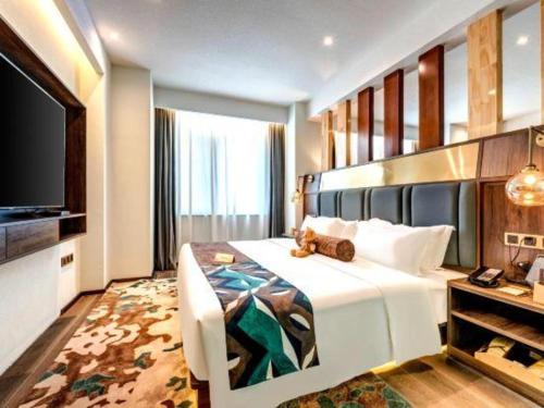 a bedroom with a bed with a teddy bear on it at James Joyce Coffetel·Anyang Text Museum in Anyang
