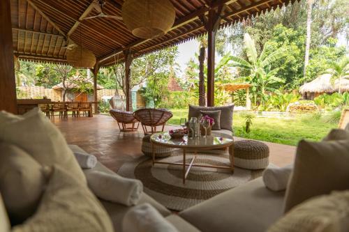 a living room with a couch and a table at AMAN Villas & SPA in Gili Air