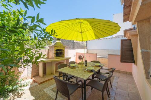 a table and chairs with a yellow umbrella on a patio at Cas Mure in Porreres