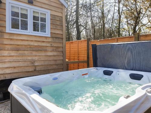 a hot tub sitting next to a building at Spire View Hut in Shootend