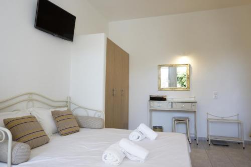a bedroom with a white bed with towels on it at Casa Nostra Mykonos Boutique Rooms & Studios in Glastros