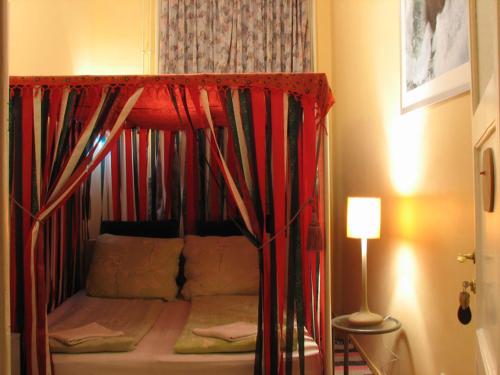 ブダペストにあるロコモーティブ ホステルのベッドルーム1室(天蓋付き二段ベッド、ランプ付)