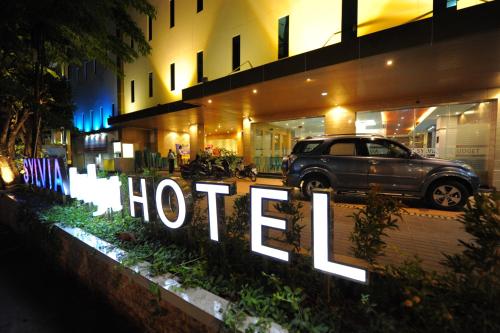 un coche aparcado delante de un hotel por la noche en Sylvia Hotel Budget, en Kupang