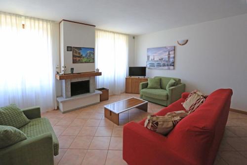 ein Wohnzimmer mit einem roten Sofa und einem Kamin in der Unterkunft North Wind Camping & Apartment in Domaso