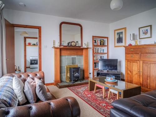 a living room with a couch and a fireplace at The Nicolson House in Graver