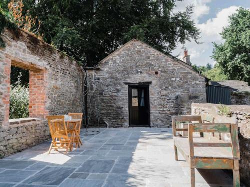 a patio with two chairs and a building at Blackrock Barn in Clifford