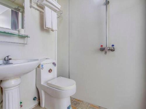 a white bathroom with a toilet and a sink at PAI Hotel Shijiazhuang Luquan Zoo in Shijiazhuang