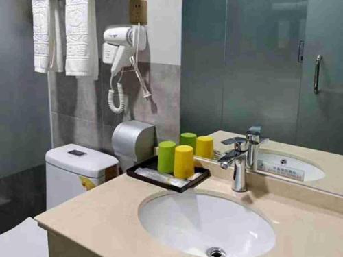 a bathroom with a sink with a blow dryer above it at Super 8 Hotel Dingzhou Chongwen Street in Baoding