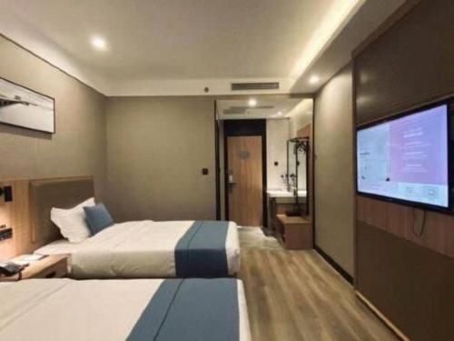 Ένα ή περισσότερα κρεβάτια σε δωμάτιο στο Shell Hotel Shandong Jinan Daming Lake