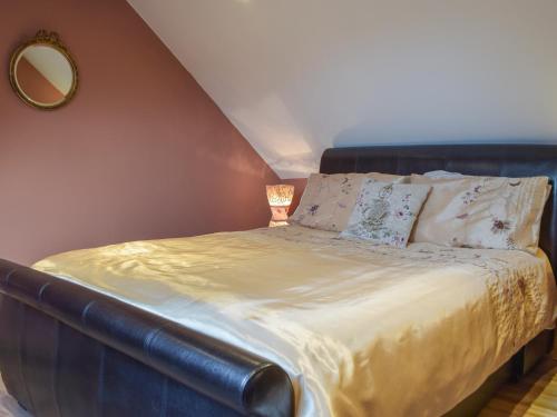 a large bed in a room with a mirror at Welshouse in Henllan