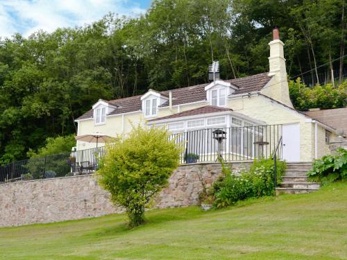 a house with a fence and a stone wall at Thornhill in Whitchurch