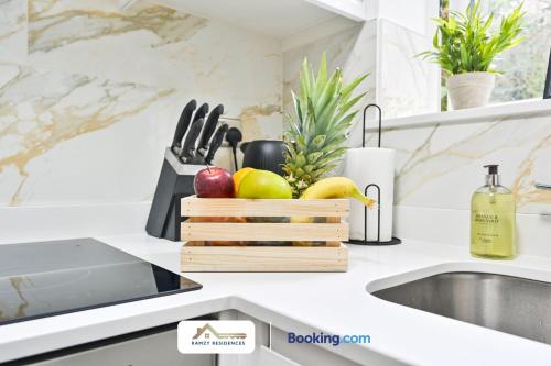 a kitchen counter with fruits and vegetables on a cutting board at 1 Bedroom Apartments By Ramzy Residences Short Lets & Serviced Accommodation In Kent With Free Wifi in Sevenoaks