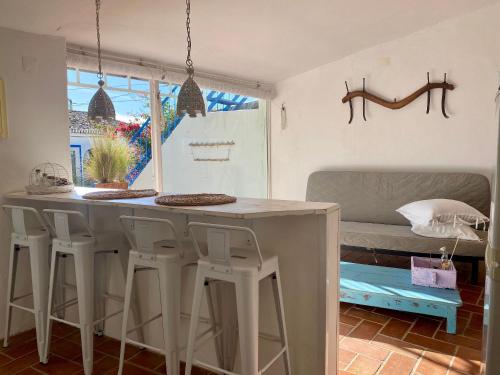 a kitchen with a table and stools in a room at Casa Da Aldeia in Santa Bárbara de Nexe