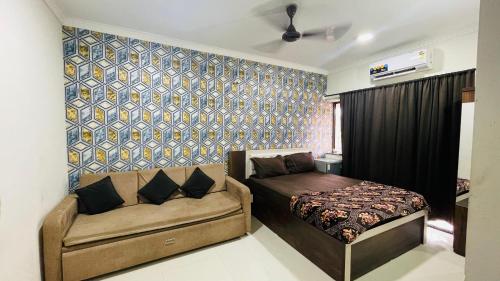 a bedroom with a bed and a couch at Studio flats in Candolim in Candolim