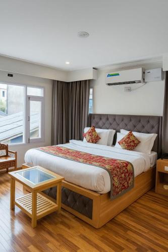 a hotel room with a large bed and a table at De Elaaf The Luxury Stay in Srinagar
