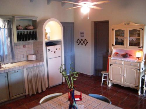 a kitchen with a table and a white refrigerator at Il Suo Paradiso in Dhavgáta