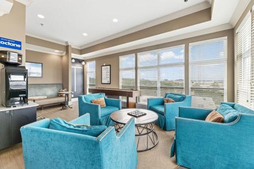 a living room with blue chairs and a table at Reynoldstown Lux 2BR, Rooftop Deck, Near Beltline & Downtown, Free Parking in Atlanta