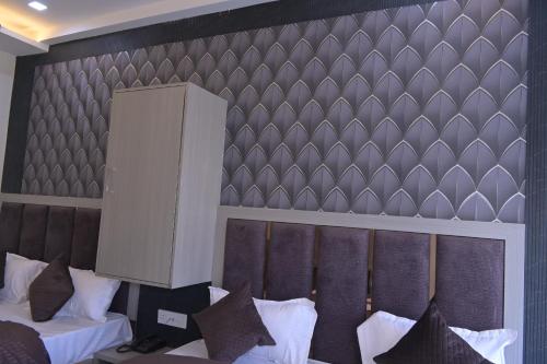 a bedroom with two beds and a wall with a headboard at hotel k stay by Anmol in Haridwār