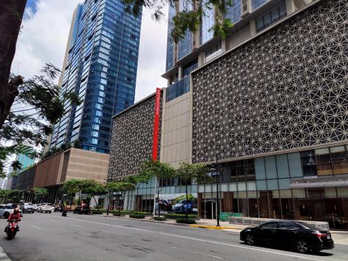 a building on a city street with cars at BGC Uptown Park Suites Tower 1 - 2 Bedroom and 2 Bath Condo in Manila