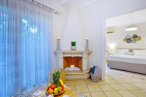 a living room with a fireplace and a bed at Delfino Blu Wellness Boutique Hotel in Agios Stefanos