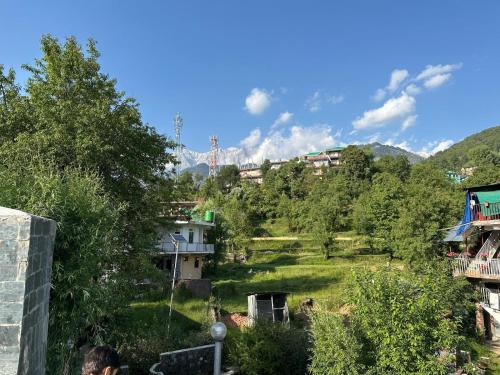 a view of a hill with buildings and trees at Tranquil trails home stay naddi in Dharamshala