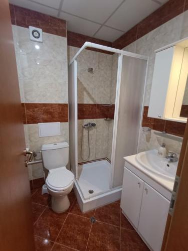 a bathroom with a shower and a toilet and a sink at Riviera Fort Beach Apartment in Ravda
