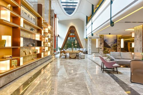 a lobby with a couch and chairs in a building at Atour Hotel Dalian Hi-tech Zone in Dalian