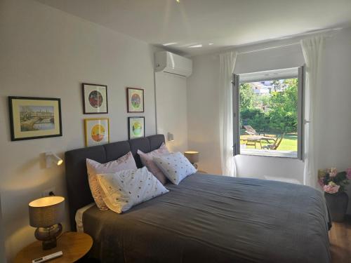 een slaapkamer met een bed met kussens en een raam bij Holiday House Altea in Banjole