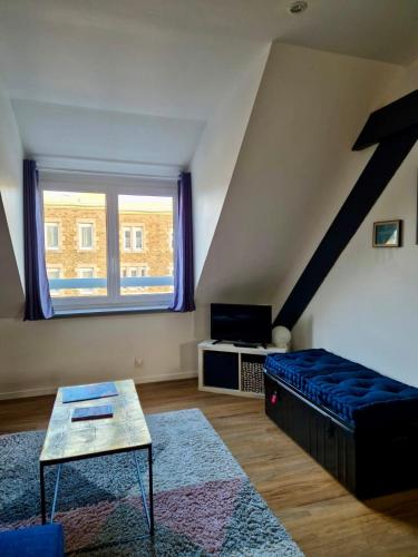 un salon avec un canapé bleu et une fenêtre dans l'établissement CLINT HOUSE - Appartement 