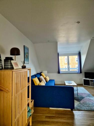 un salon avec un canapé bleu et une fenêtre dans l'établissement CLINT HOUSE - Appartement 