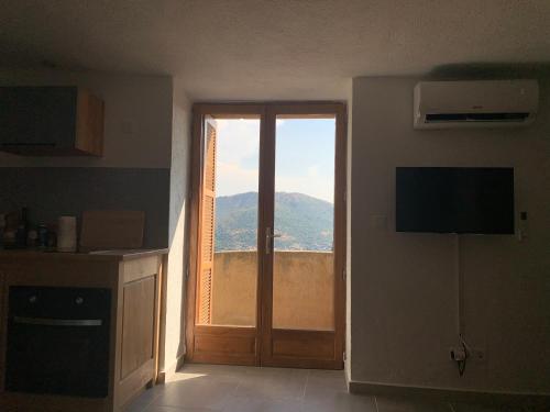 Cette chambre dispose d'une porte offrant une vue sur la montagne. dans l'établissement Bella Vista, à SantʼAntonino