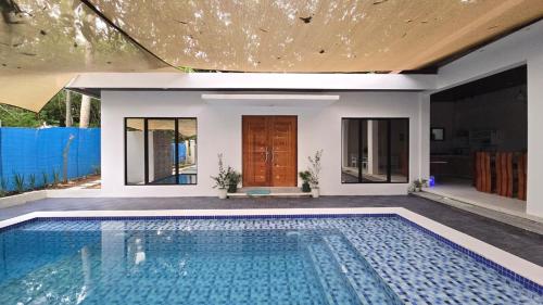 a swimming pool in front of a house at Casa Zavia in Sampong