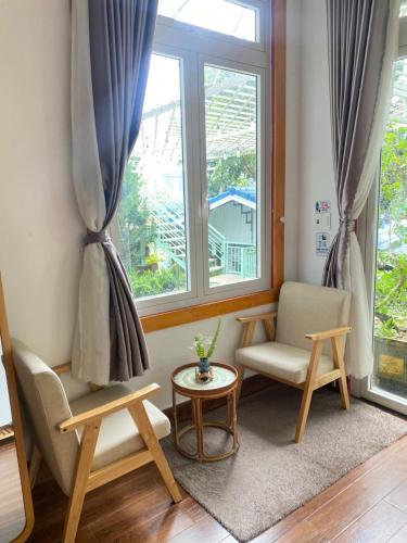a living room with a chair and a window at 3 Tầng Mây Homestay & Coffee in Xuân Thọ