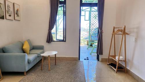 a living room with a couch and a table at 3 Tầng Mây Homestay & Coffee in Xuân Thọ