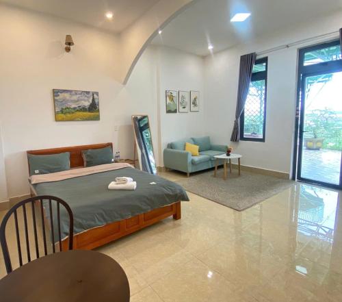 a bedroom with a bed and a chair and a couch at 3 Tầng Mây Homestay & Coffee in Xuân Thọ