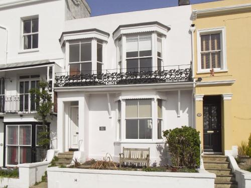 a white house with a yellow house at Bay House in Hastings