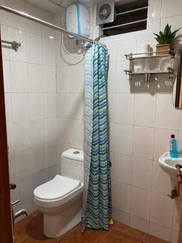 a bathroom with a toilet and a sink at Studio apartment in split level bungalow with pool access in Cochin