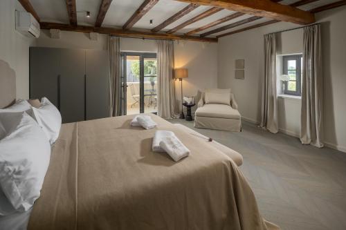 a bedroom with a large bed with towels on it at San Tomasini Heritage Hotel & Wedding Venue in Višnjan