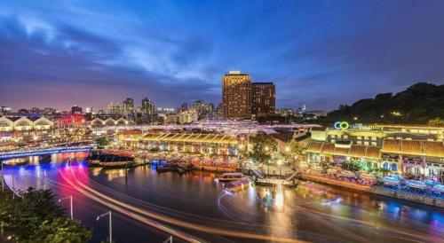a city at night with a river and buildings at Hotel Miramar Singapore in Singapore