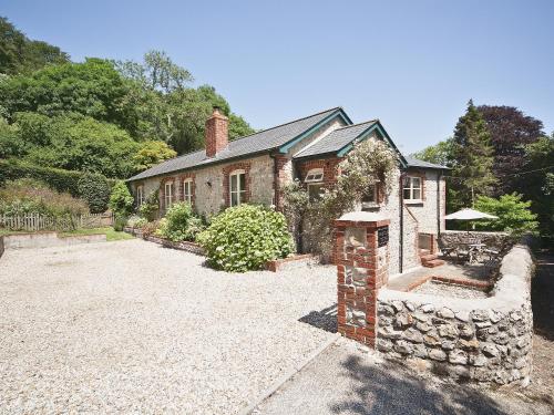 an old brick house with a stone wall at Ware House Cottage in Lyme Regis