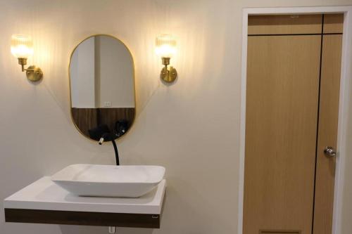 a bathroom with a white sink and a mirror at The Loom Rangsit in Pathum Thani