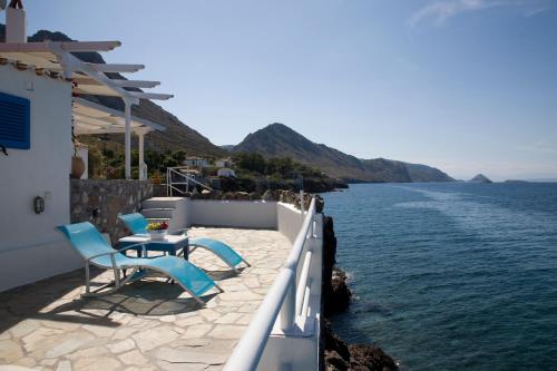 a patio with chairs and a view of the water at Villa Ostria in Vlikhós