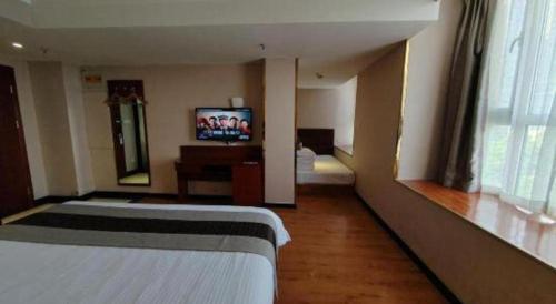 a hotel room with a bed and a television at GreenTree Inn Luoyang Zhongzheng Street Express Hotel in Luoyang